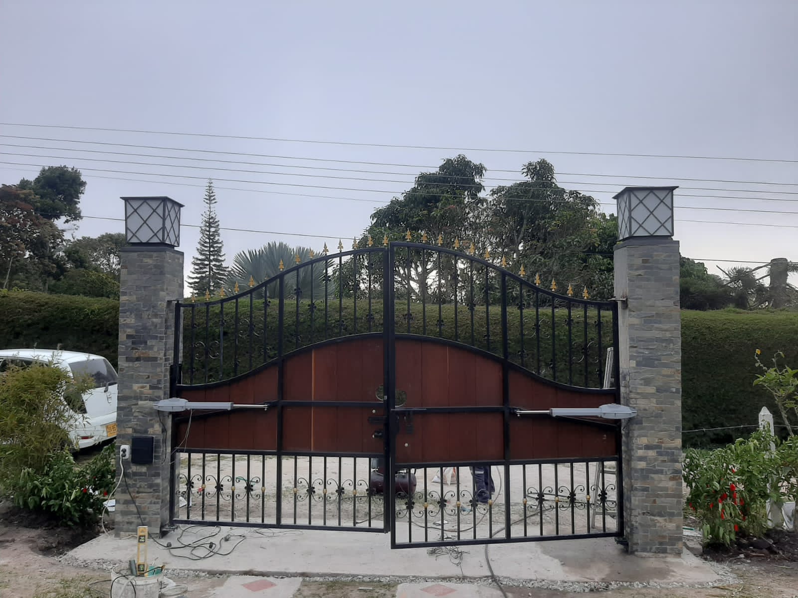 Portón batiente ornamental con dos motores de brazo instalados